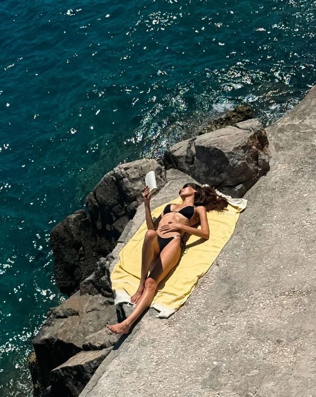 Kitap okurken güneşleniyor