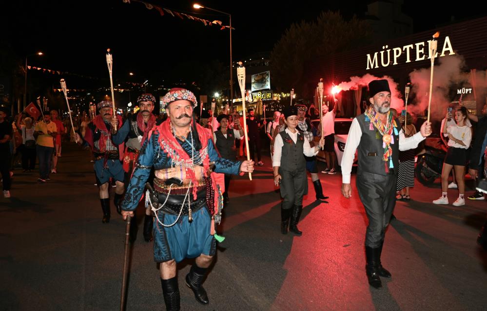 Ellerinde Türk bayrakları ve Atatürk posterleri taşıyan Kuşadalılar, çalınan marşlar eşliğinde meşalelerle İsmail Cem Dostluk ve Barış Meydanı’na yürüdü. 